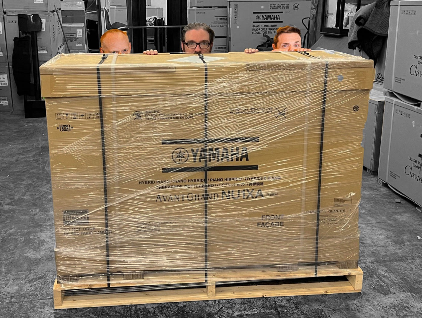 A boxed Yamaha piano strapped to a custom shipping pallet built to protect it in transit
